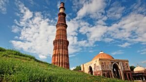 Qutub Minar with clear blue sky in Delhi – popular tourist attraction surrounded by top restaurants near Qutub Minar